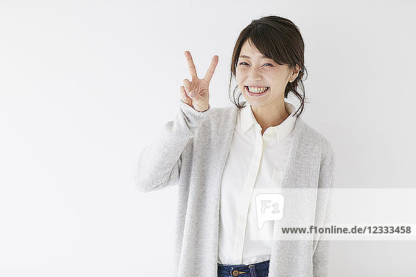 Junge japanische Frau vor weißer Wand