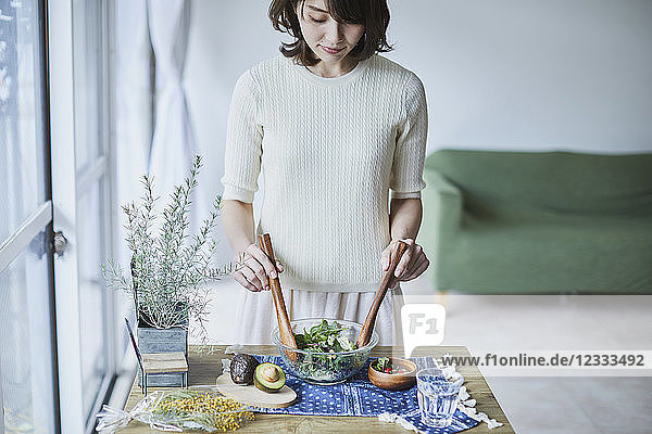 Young Japanese woman preparing salad