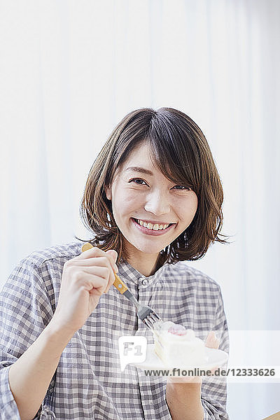 Junge Japanerin isst Kuchen