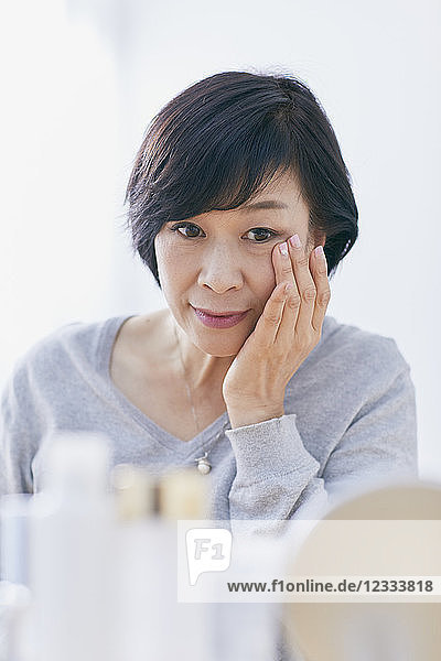 Japanische Seniorin bei der Hautpflege