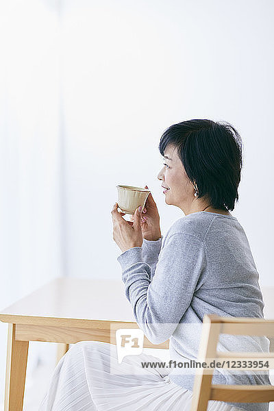 Japanische Seniorin beim Kaffee trinken