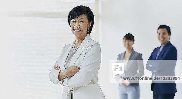 Japanische Senior-Geschäftsfrau mit ihrem Team