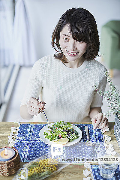 Young Japanese woman eating salad
