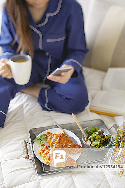 Japanische Frau beim Frühstück im Bett