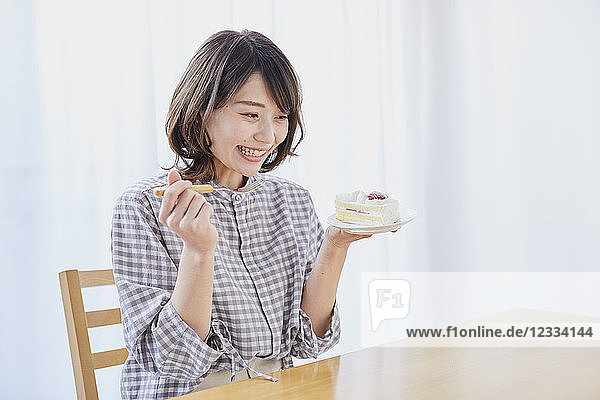 Young Japanese woman eating cake