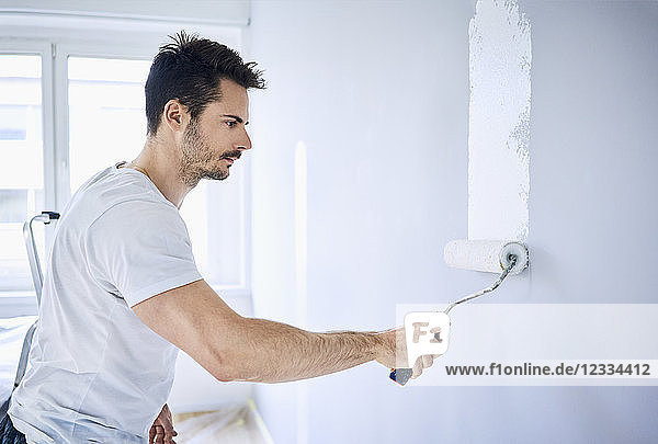 Man painting wall in apartment