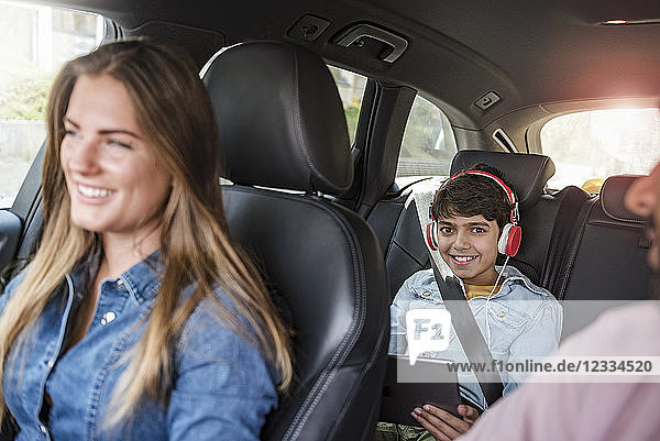Family on a road trip with boy using tablet