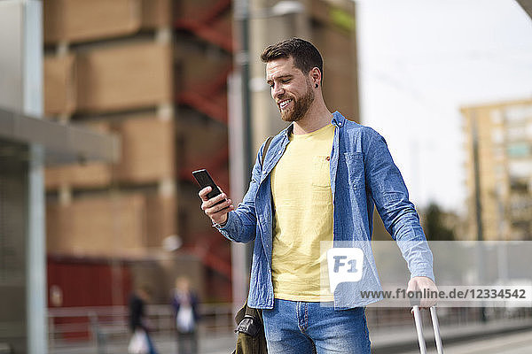 Young man with smartphone at station