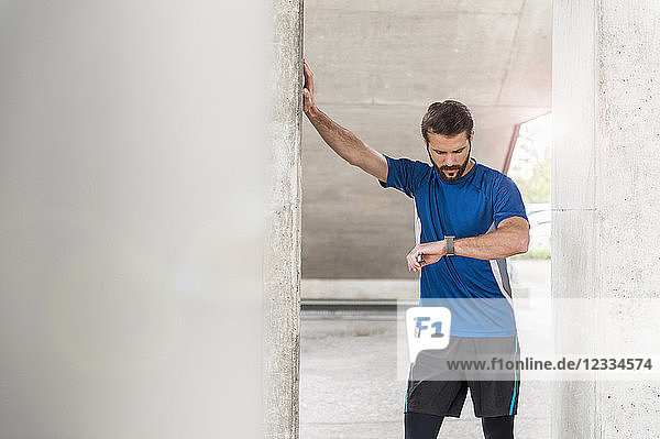 Man having a break from running checking the time