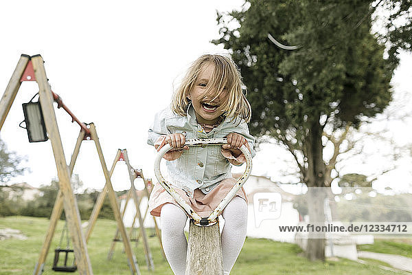 Excited little girl having fun on a seesaw