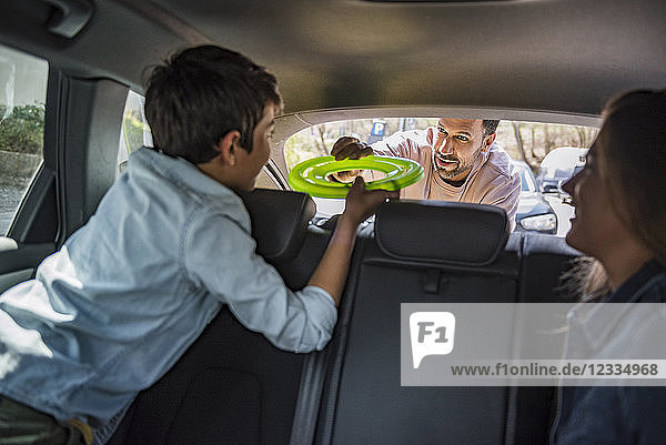 Fathe giving boy flying disc in car