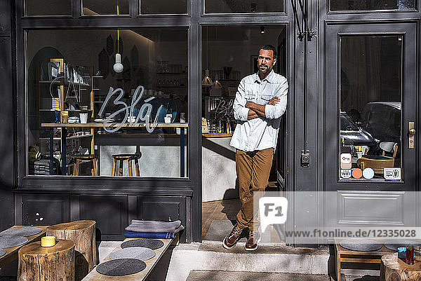 Man standing at entrance door of a cafe