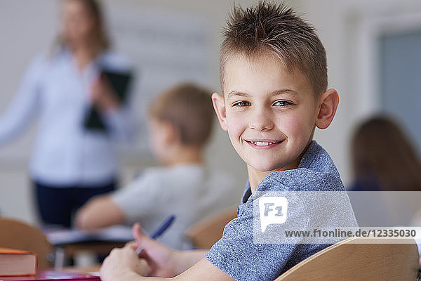 Portrait of smiling schoolboy in class