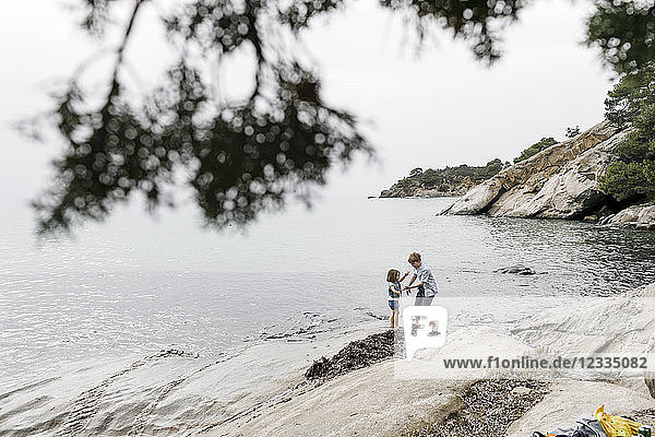 Greece Chalkidiki brother and little sister playing together on the beach