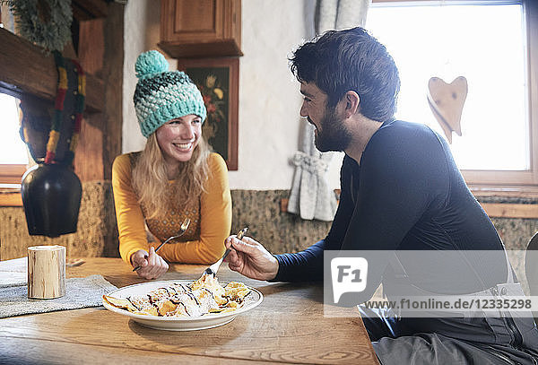 Happy couple eating in rustic mountain hut