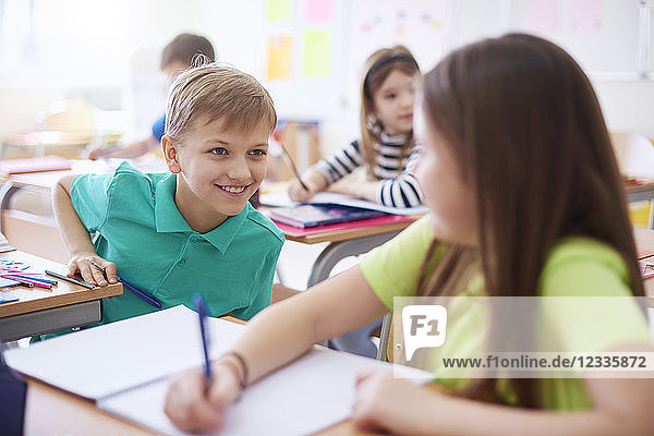 Schoolboy smiling at schoolgirl in class