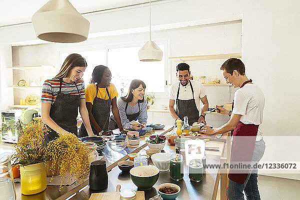 Friends and instructor in a cooking workshop preparing food