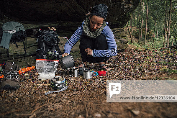 Young woman on a trekking tour preparing drinks