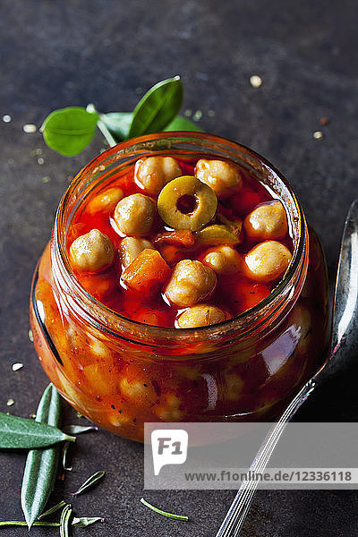 Glass of chick-pea stew with green olives