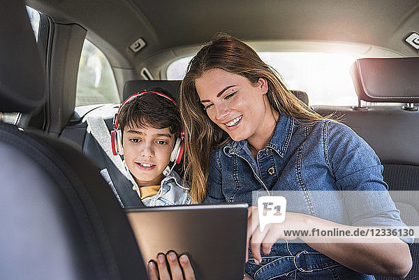 Family on a road trip with mother and son sharing tablet