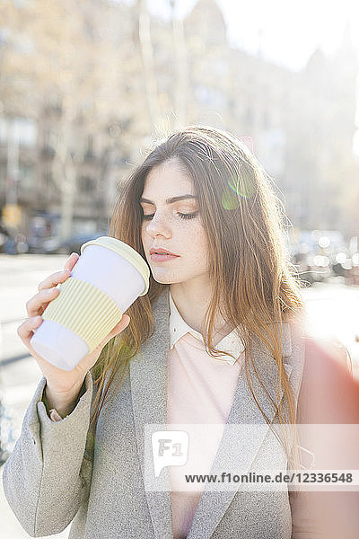 Spain  Barcelona  portrait of young woman drinking coffee to go