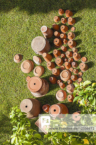 Empty flower pots standing upside down on grass