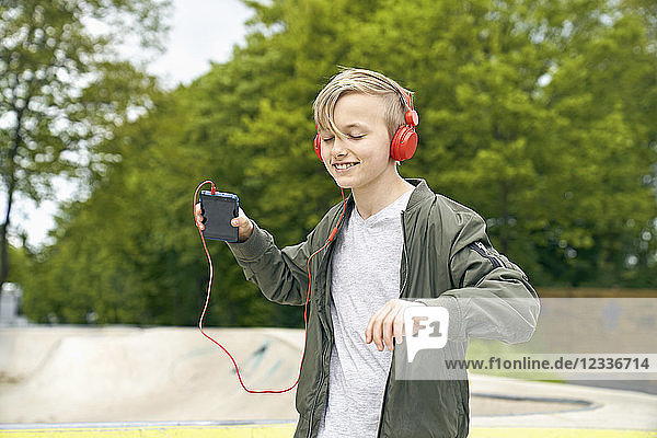 Boy with headphone dancing while listing to music on smartphone