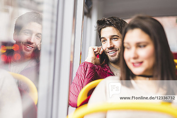 UK  London  portrait of smiling young man on the phone in a bus