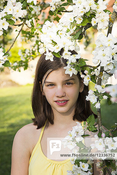 Portrait of girl with twig of blossoming apple tree