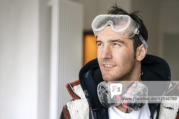 Portrait of a handyman   renovating flat  looking through window