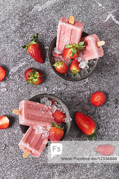 Homemade strawberry ice lollies in bowls