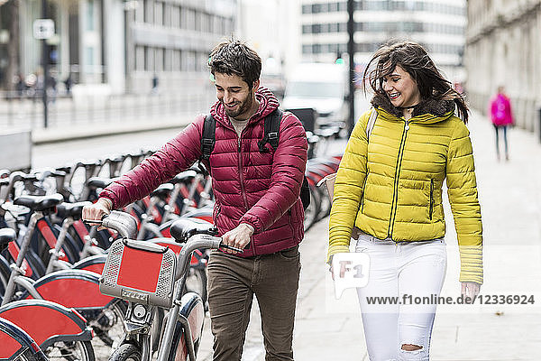 UK  London  young couple with rental bicycle from bike share stand