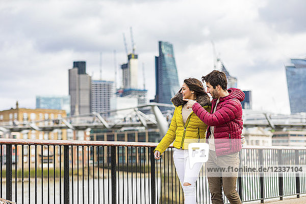 UK  London  young couple walking on bridge watching something