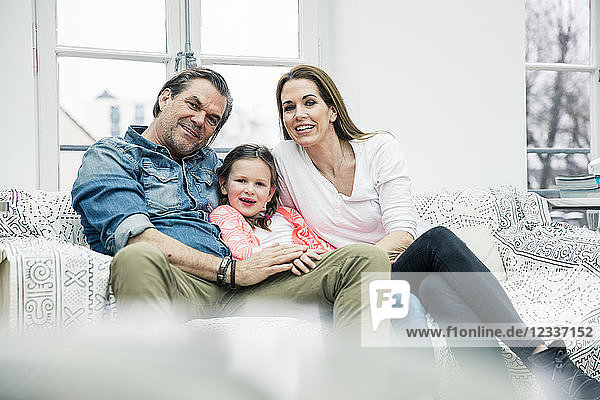 Portrait of happy family sitting on couch