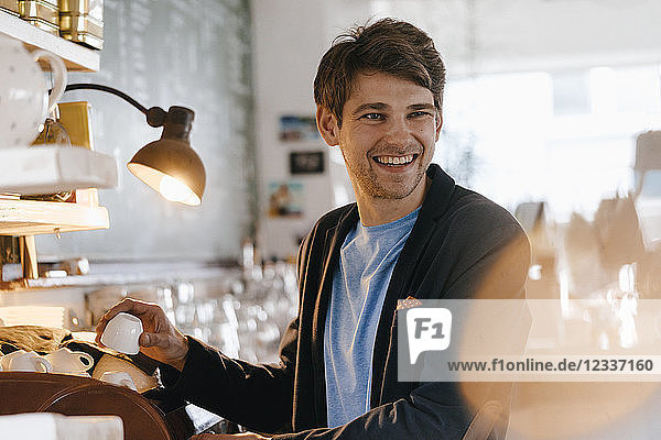 Smiling man in a cafe holding cup