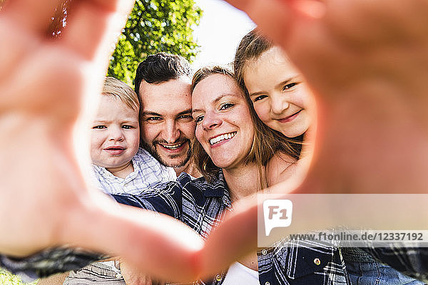 Portrait of happy family looking through finger frame