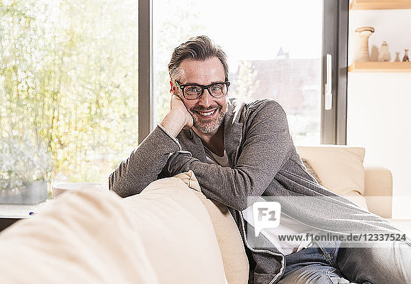 Portrait of smiling man relaxing on couch at home