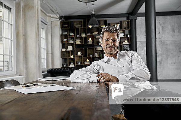 Portrait of mature businessman in loft office