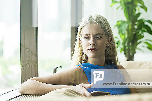 Portrait of attractive woman relaxing on couch at home