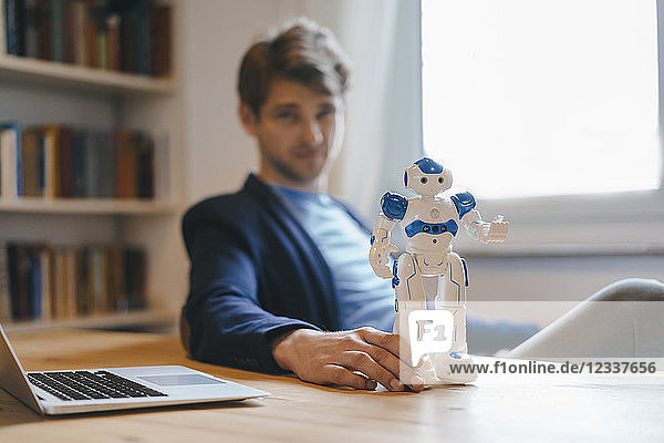 Man sitting at table with robot