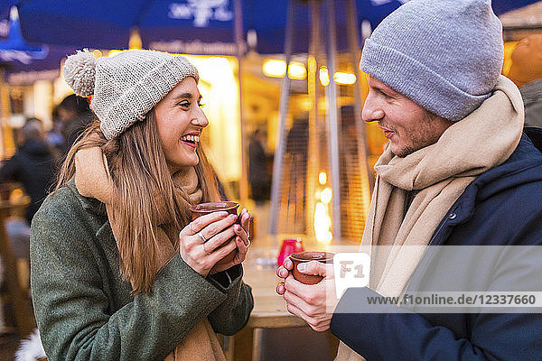 Happy young couple drinking mulled wine at Christmas market
