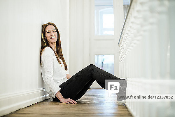 Portrait of smiling woman at home sitting on the floor