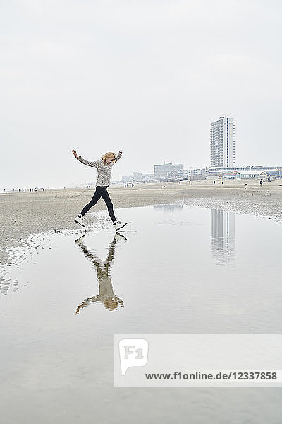 Netherlands  Zandvoort  young woman having fun on the beach