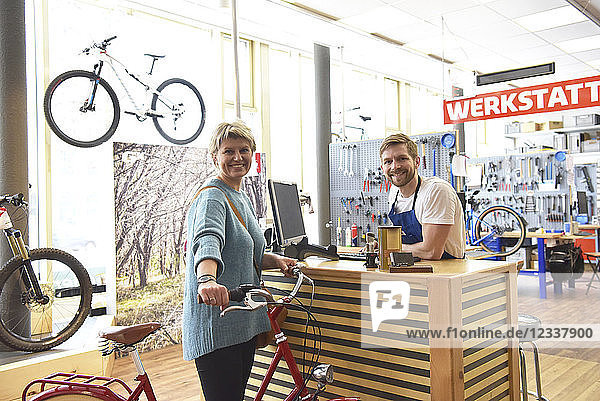 Salesperson helping customer in bicycle shop