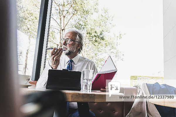 Mature businessman working at table in a cafe