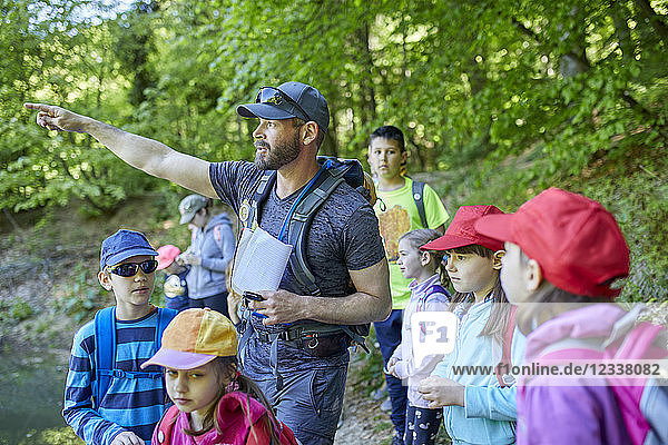 Man talking to kids on a field trip in forest