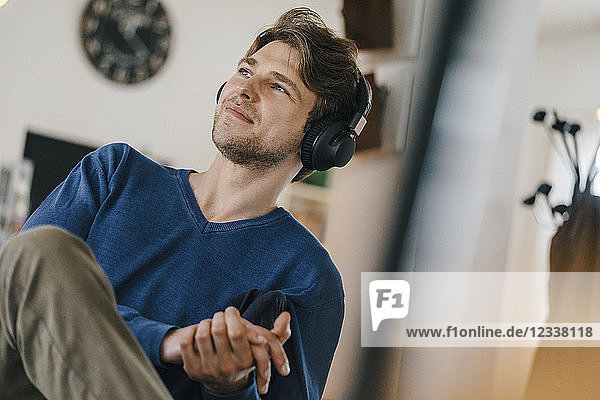 Smiling man in a cafe wearing headphones