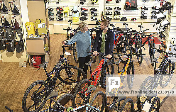 Salesperson helping customer in bicycle shop