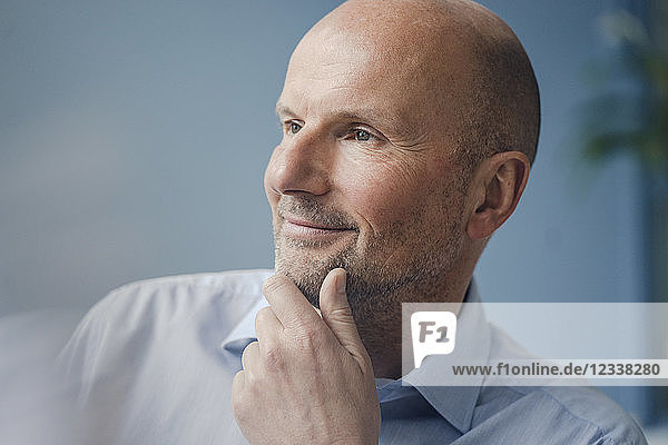 Portrait of smiling mature businessman looking sideways