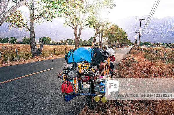 Loaded touring motorcycle parked on roadside  High Sierra National Forest  California  USA